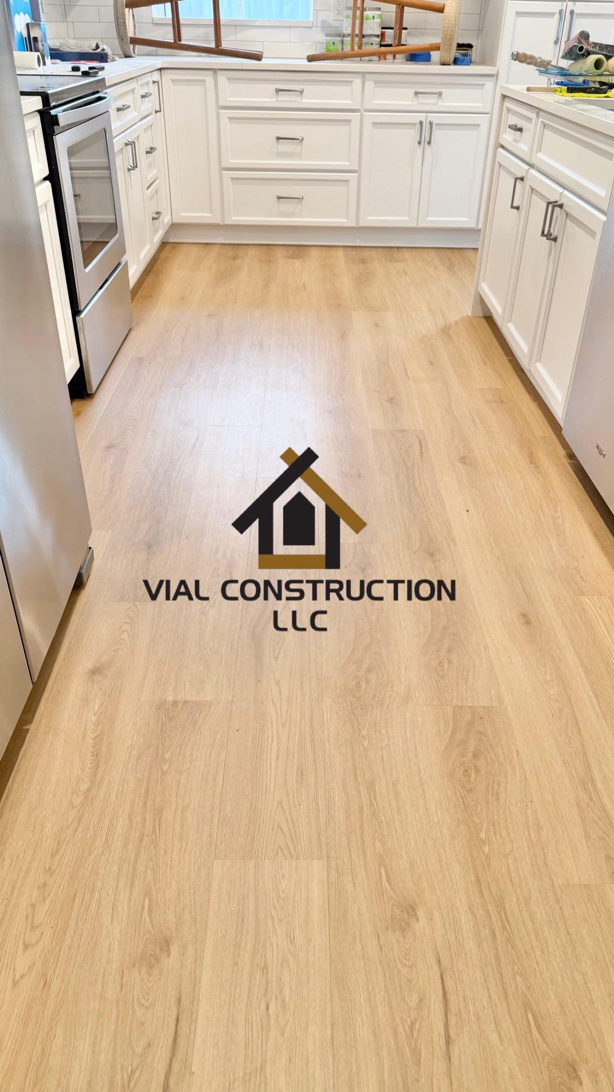 New light-colored flooring in a kitchen, with the original Vial Construction watermark